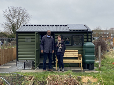 Kwasi stands in front of community shed